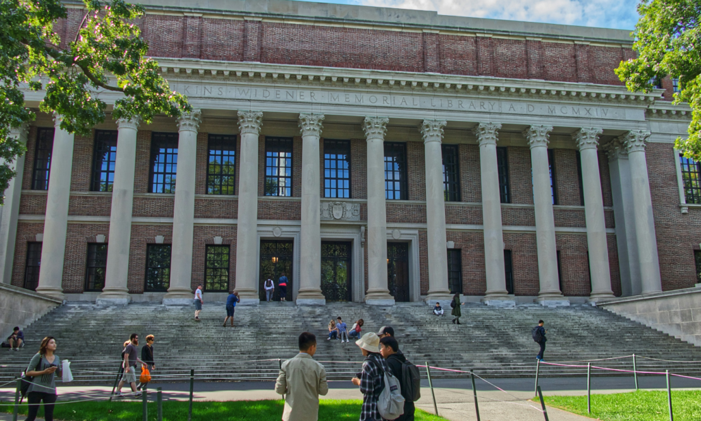 Harvard University Widener Library with students walking and sitting on the steps in front of the historic building