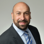 Profile picture of Michael Waksman, former CEO of Jetico, wearing a suit and blue striped tie, smiling