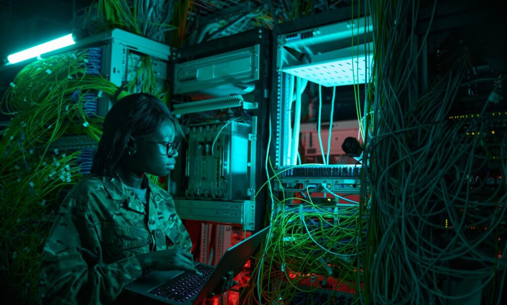 Military woman using a computer to access servers, ensuring DoD-compliant data wiping for secure operations