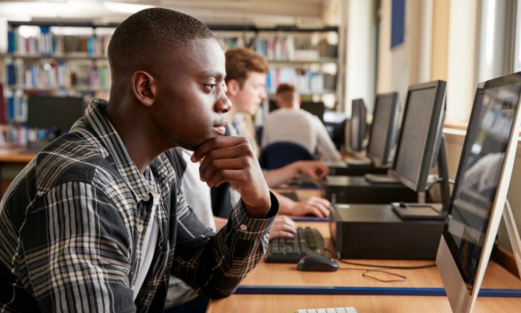 Student in a computer lab working on a desktop computer sanitized with BCWipe