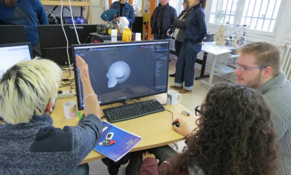 Students in a community technology lab working on a 3D modeling project, illustrating the importance of securely erasing computer hard drives before donating to educational and community programs to prevent data breaches.