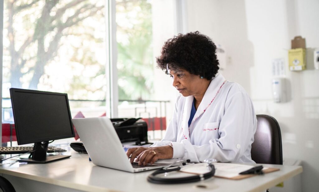 Doctor securely accessing sensitive patient data on a laptop, ensuring HIPAA compliance for healthcare privacy and data protection.